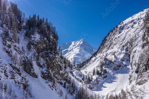 Alps mountain peak beetween two mountains full of snow and spruces © Sid Smith