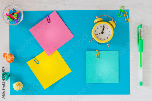 Colorful cards with space for an inscription, clock showing five minutes to twelve.  office or business concept.