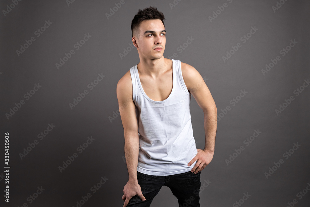 Young serious man posing in studio. Gray background Young serious man posing in studio. Gray background