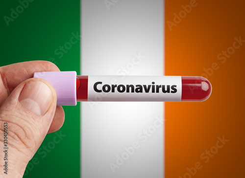 Scientist holding Coronavirus infected blood in test tube in front of Ireland flag. Pandemic COVID-19 infection in countries in world concept.
