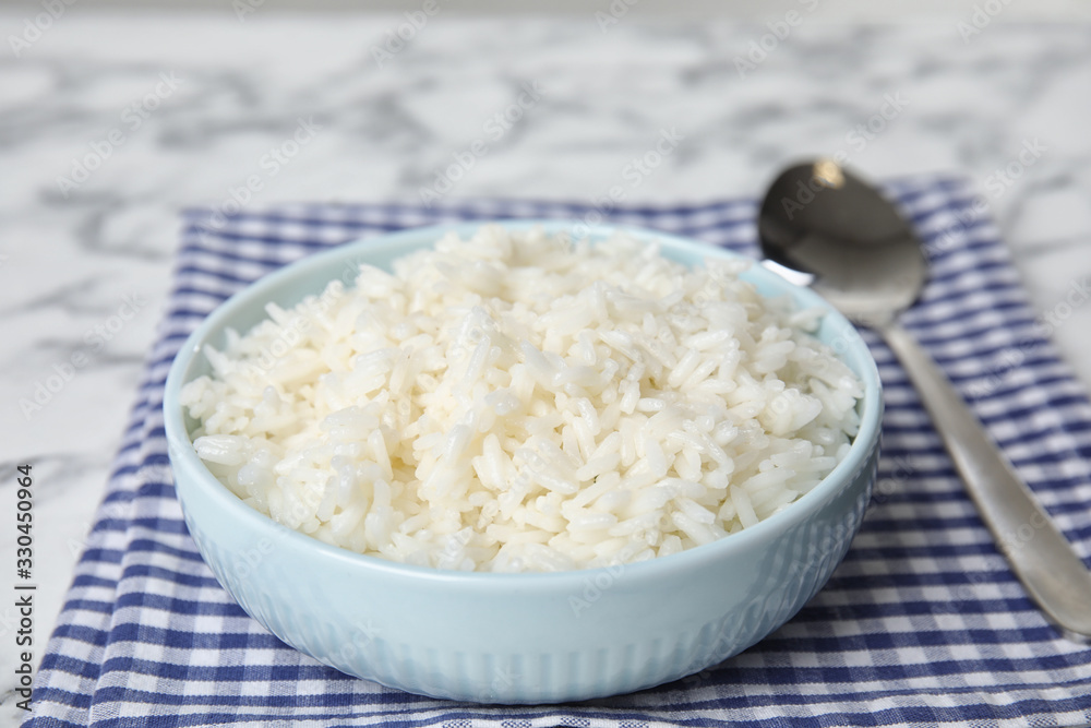 Bowl with tasty cooked rice on table, closeup Bowl with tasty cooked rice on table, closeup