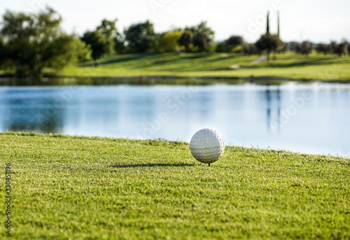 Golf ball on the green with warm tone and sunset