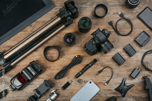 Flat lay composition with camera and video production equipment on wooden table