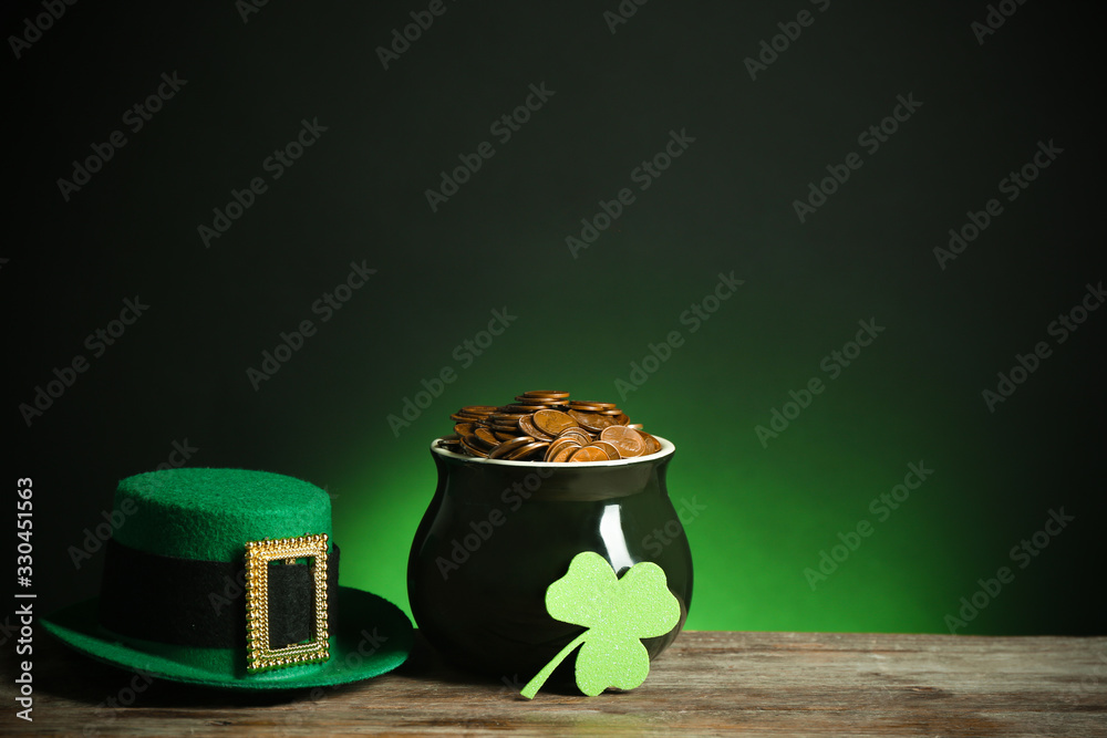 Pot with gold coins, hat and clover on wooden table against dark background, space for text. St. Patrick's Day - obrazy, fototapety, plakaty 