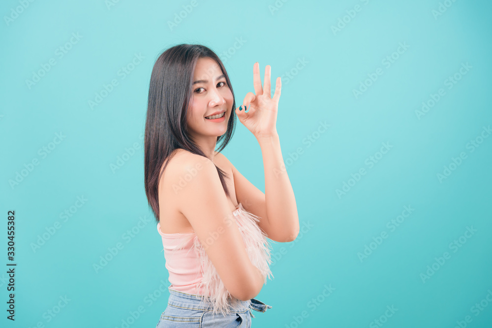 woman standing smiling her show finger OK sign woman standing smiling her show finger OK sign