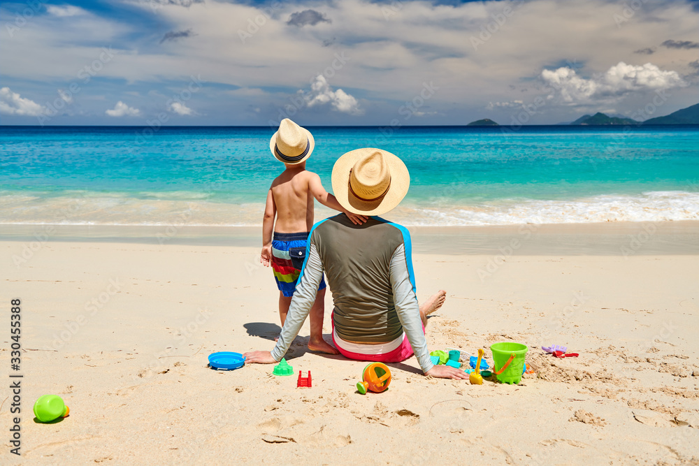 Toddler boy on beach with father Toddler boy on beach with father