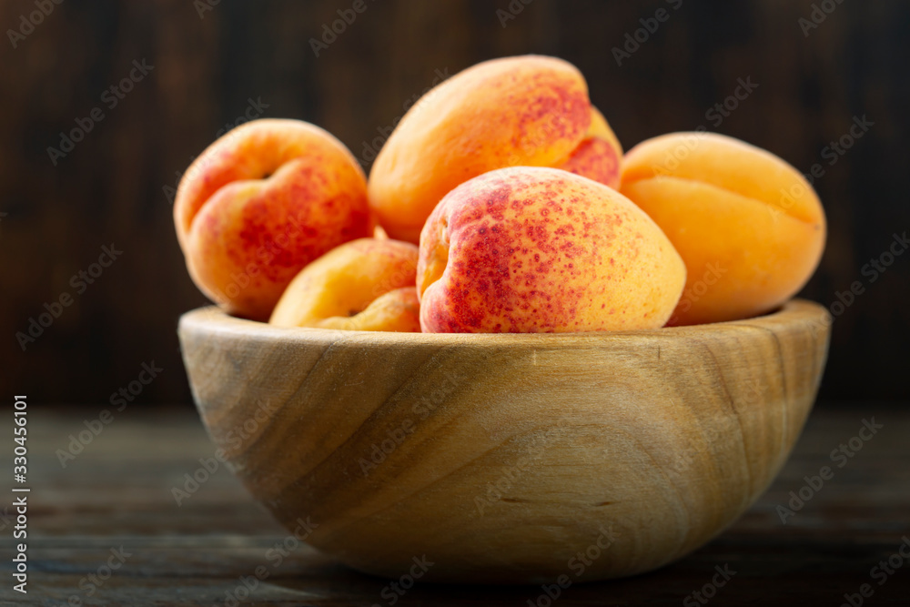 Ripe apricots in a wooden bowl. Ripe apricots in a wooden bowl.
