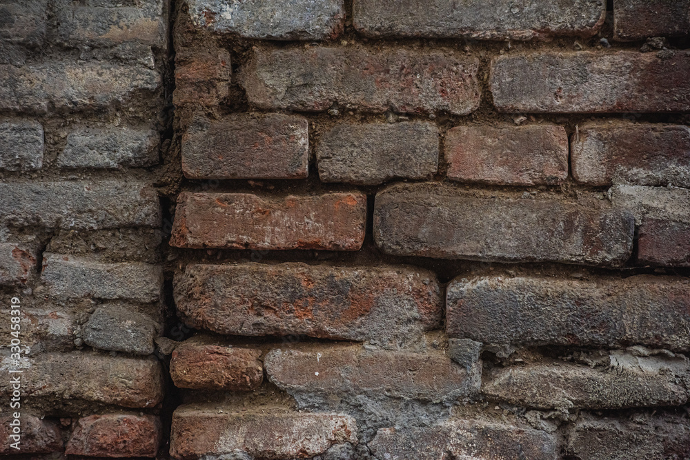 Naklejka premium Holes in a damaged brick wall is close