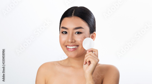Korean Woman Holding Cotton Pad Near Face On White Background