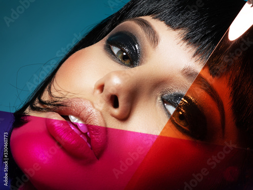Glamour fashion model with black gloss make-up. Beautiful fashion woman with a colored items. Attractive white girl with coral color lipstick.  Stylish fashionable concept. Art. Black eye-makeup