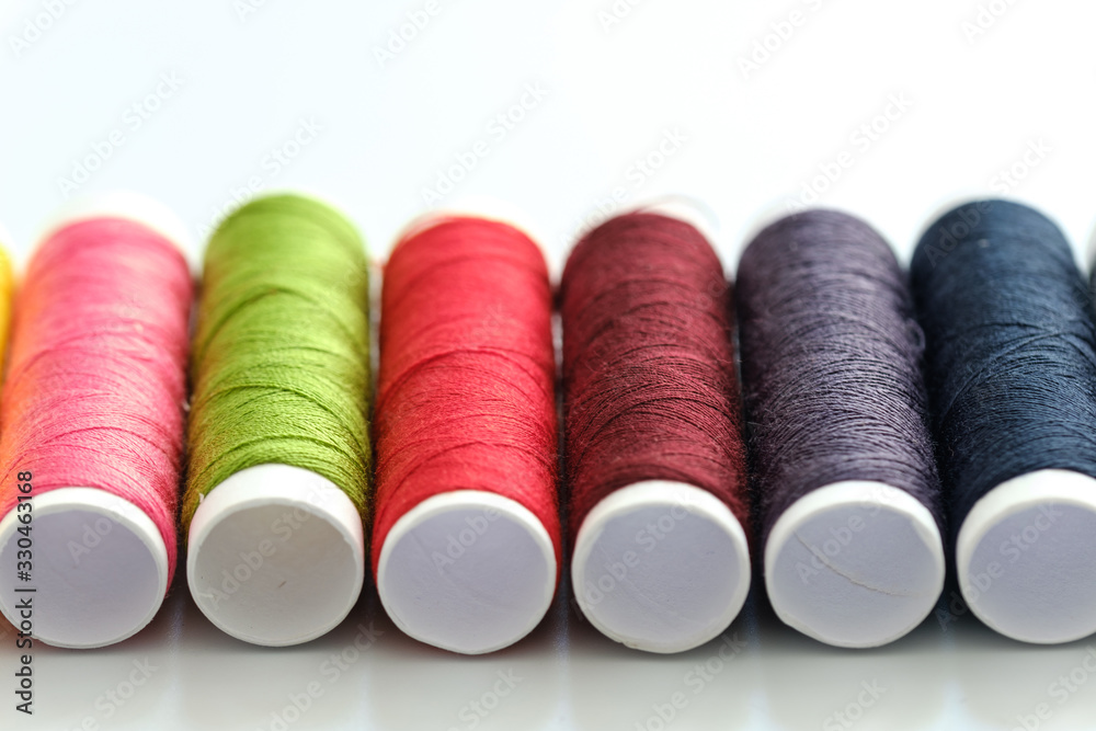 Close up macro view of colorful yarn reels on white background Close up macro view of colorful yarn reels on white background