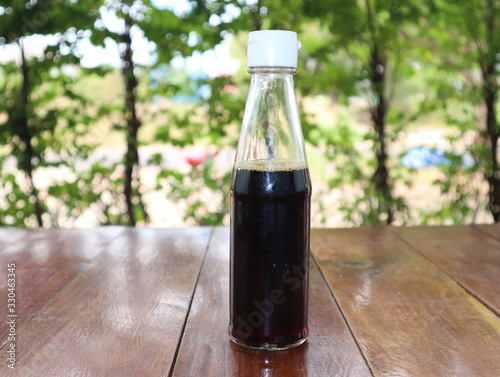 Fish sauce in a glass jar placed on a wooden table.