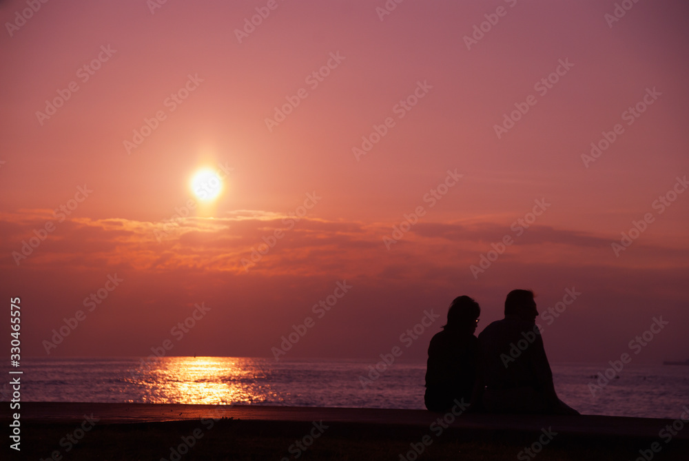 夕陽とカップルのシルエット