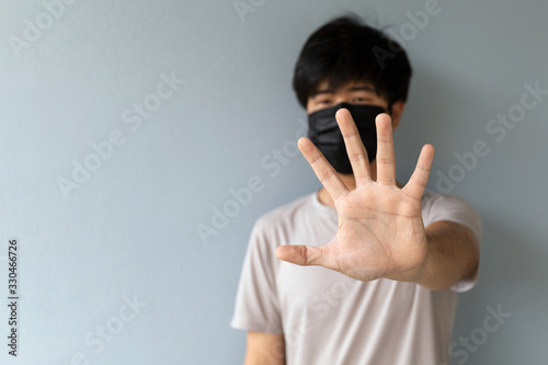 closeup men wearing a mask to protect the coronavirus (COVID-19) and PM2.5 dust with showing palm hand. soft-focus and over light in the background