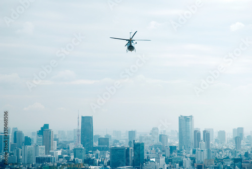 ビル群に向かって飛ぶヘリコプター
