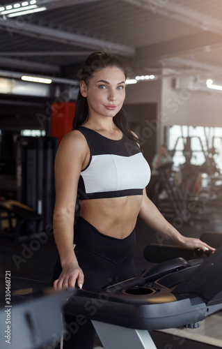 Caucasian woman standing on treadmill in sportsclub