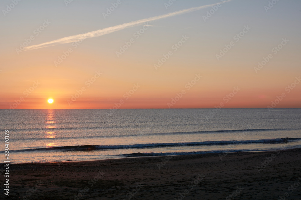 Fishermen on the beach groyne at sunrise,