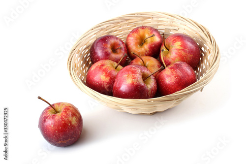 Red little apples on wicker plate
