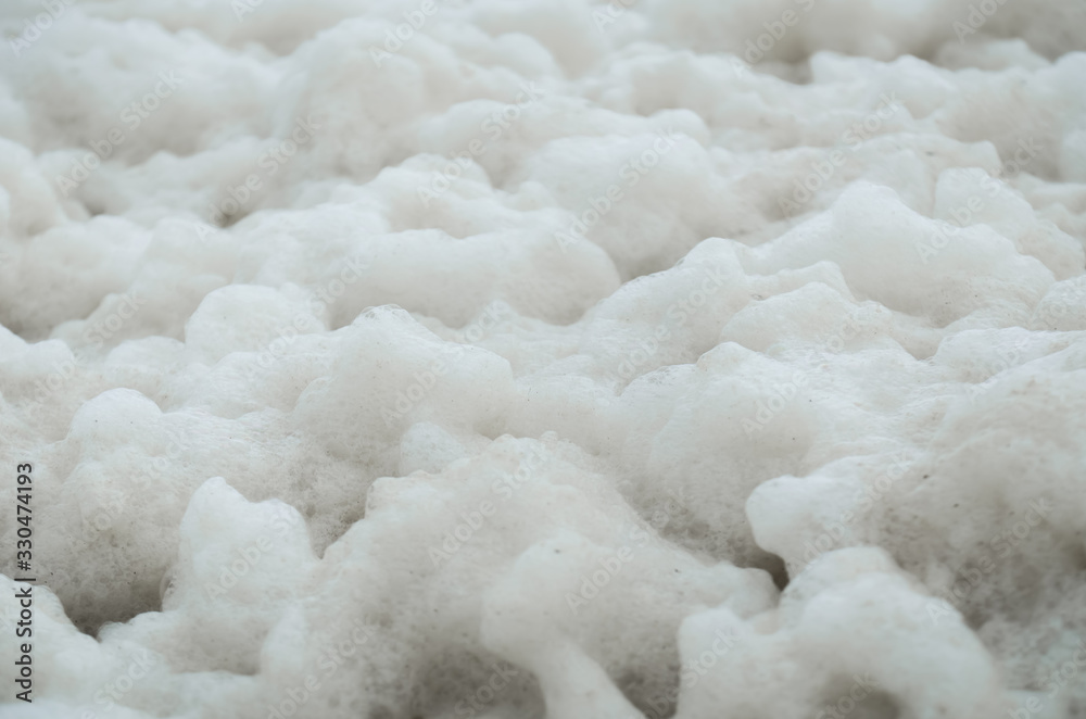 Abstract close-up of a lot of sea foam on the shore. Ecology.