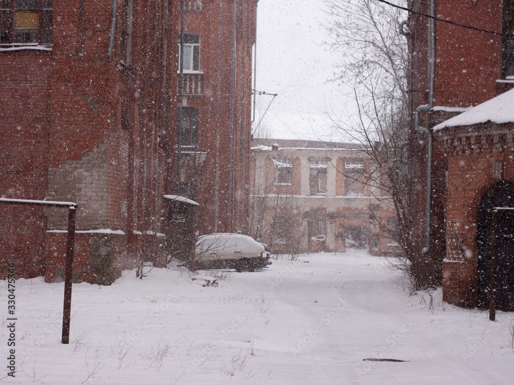 Fototapeta premium old red brick houses in heavy snowfall