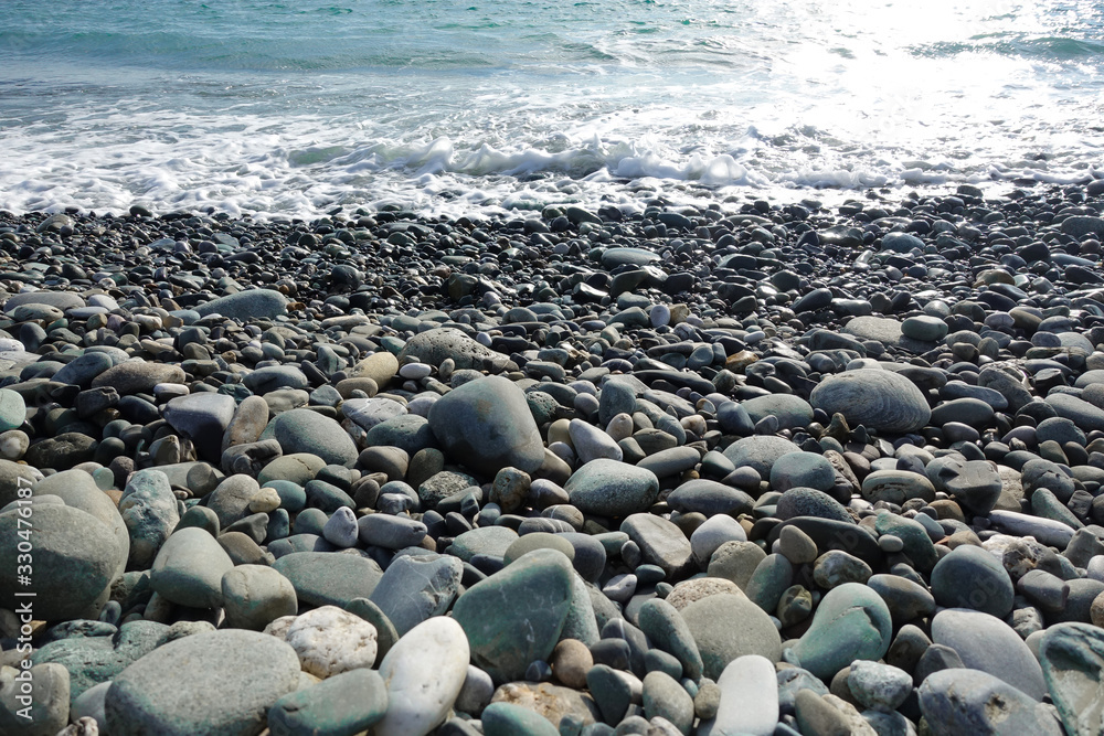 Sea shore with pebbles. wet sea pebbles on the beach and quiet sea surf Sea shore with pebbles. wet sea pebbles on the beach and quiet sea surf