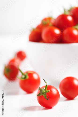red cherry tomato in  ceramic bowl on white background © janecocoa