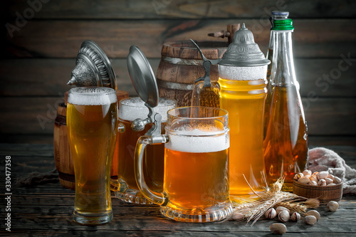 Light frothing beer in a glass, on an old background.