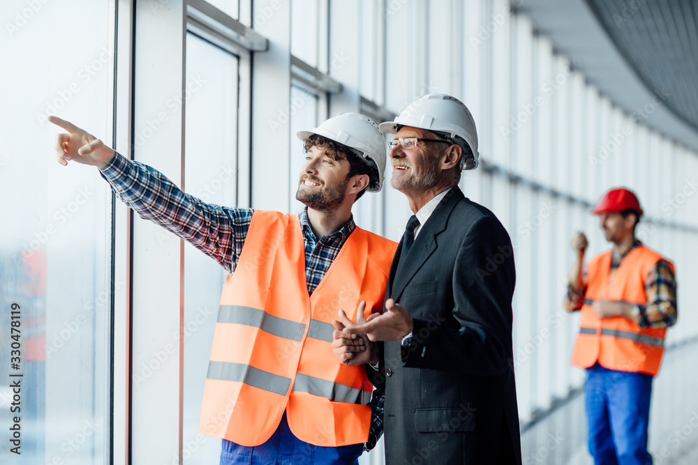 © Тарас Нагирняк - Construction worker man pointing on architectural plans and architect.