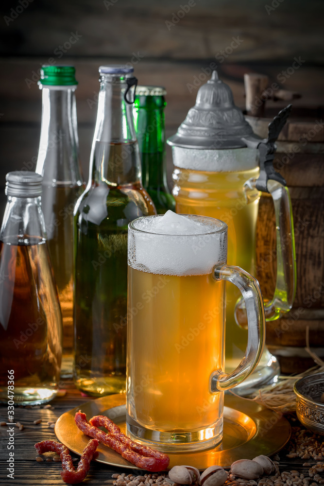 Light frothing beer in a glass, on an old background. Light frothing beer in a glass, on an old background.