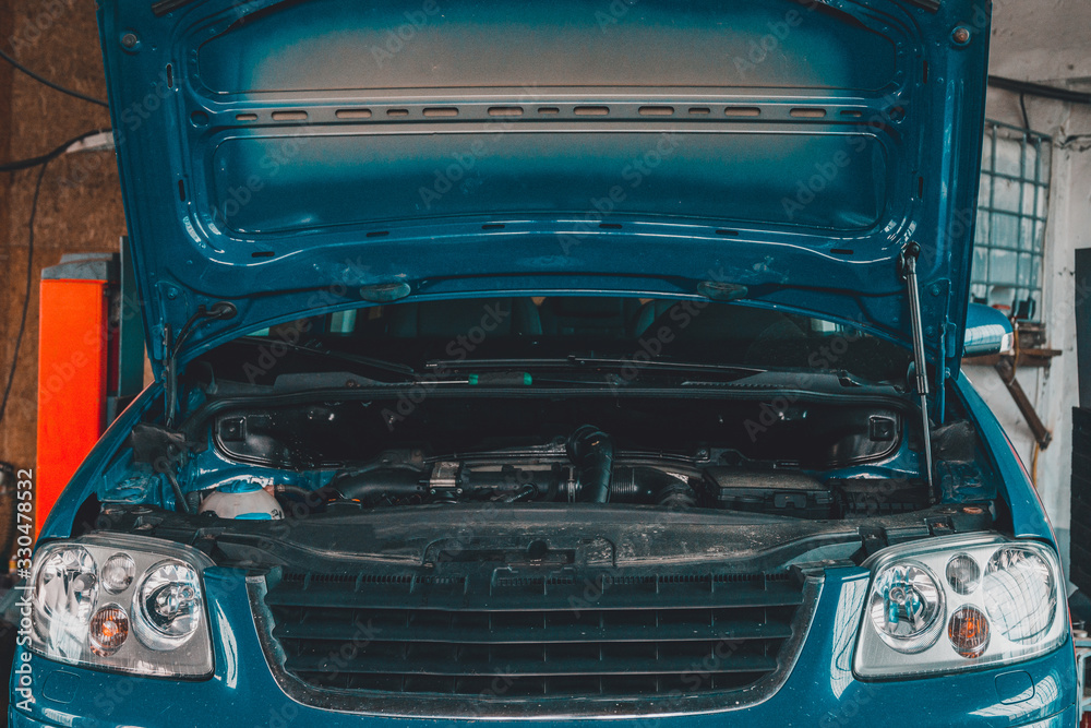 Obraz premium European car with rectangular headlights and open hood in blue closeup