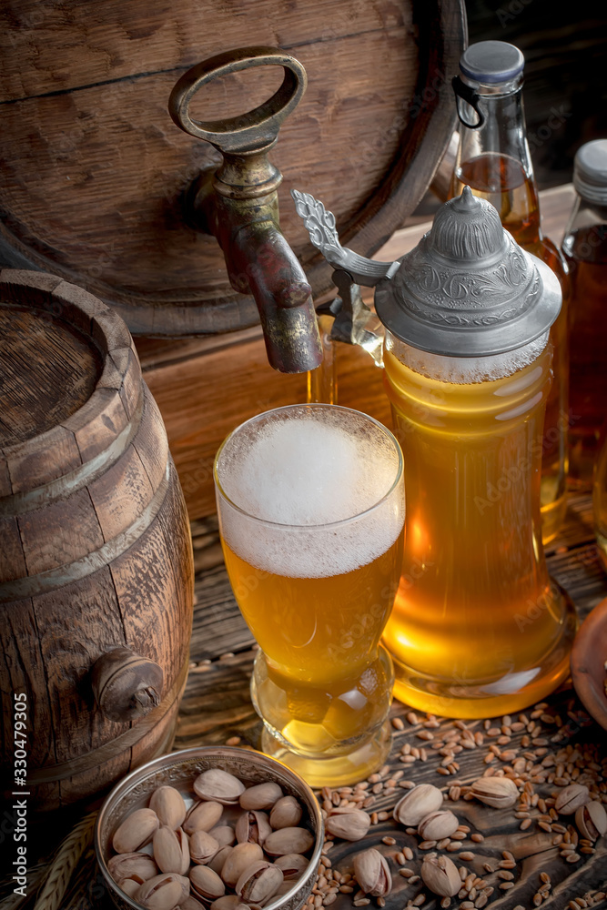 Light frothing beer in a glass, on an old background. Light frothing beer in a glass, on an old background.