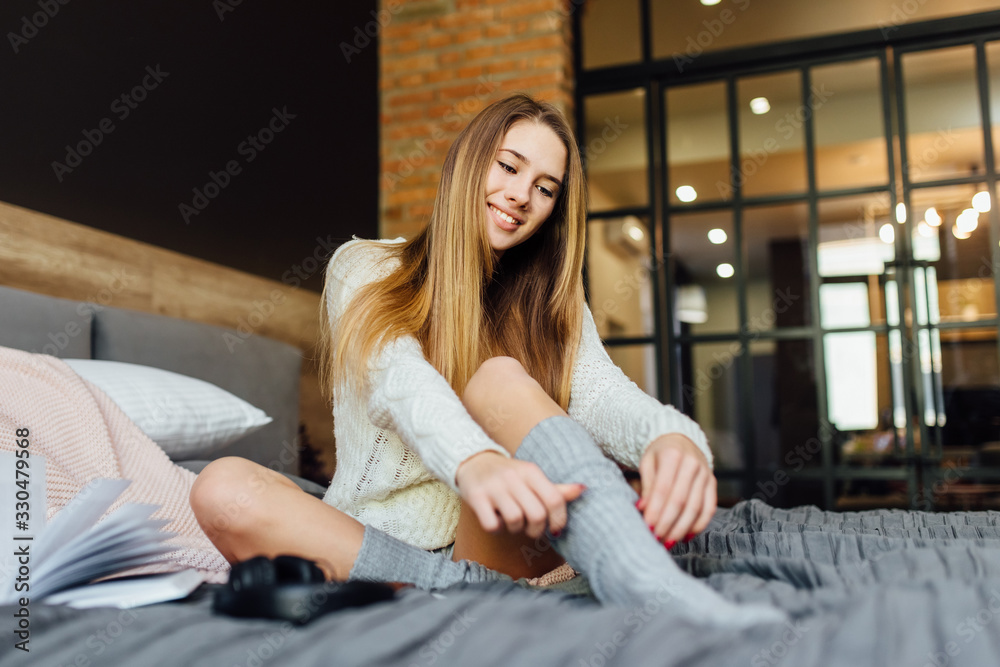 Relaxed playful female wearing t-shirt, shorts and socks having lazy morning, lying in bed. People, leisure and spare time concept. Relaxed playful female wearing t-shirt, shorts and socks having lazy morning, lying in bed. People, leisure and spare time concept.