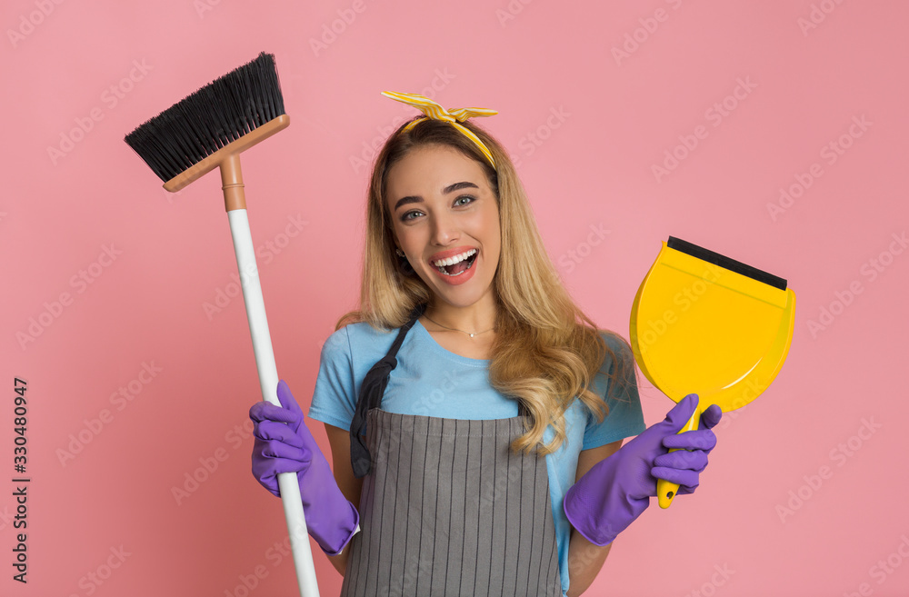 House cleaning concept. Smiling housewife with broom and shovel in hands House cleaning concept. Smiling housewife with broom and shovel in hands