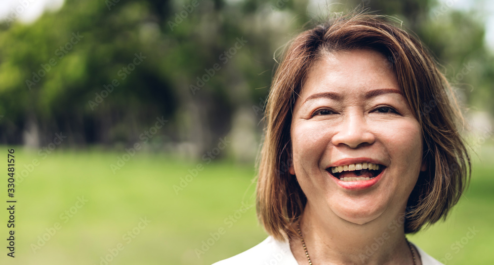 Portrait of happy senior adult elderly asian women smiling and looking at camera in the park.Retirement concept Portrait of happy senior adult elderly asian women smiling and looking at camera in the park.Retirement concept
