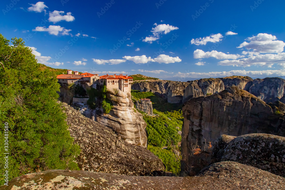 Greece. Meteora Rocks. Orthodox monastery on top of a cliff. The red-roofed monastery is located in the mountains. Christianity. Panorama of Meteora on a Sunny day. Sights Of Greece.