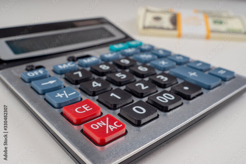 Calculator on the table close-up. Calculator on the background of bundles of dollars. Financial calculation. The calculation of profit. Budget of funds. Distribution of profits. Financial calculations Calculator on the table close-up. Calculator on the background of bundles of dollars. Financial calculation. The calculation of profit. Budget of funds. Distribution of profits. Financial calculations