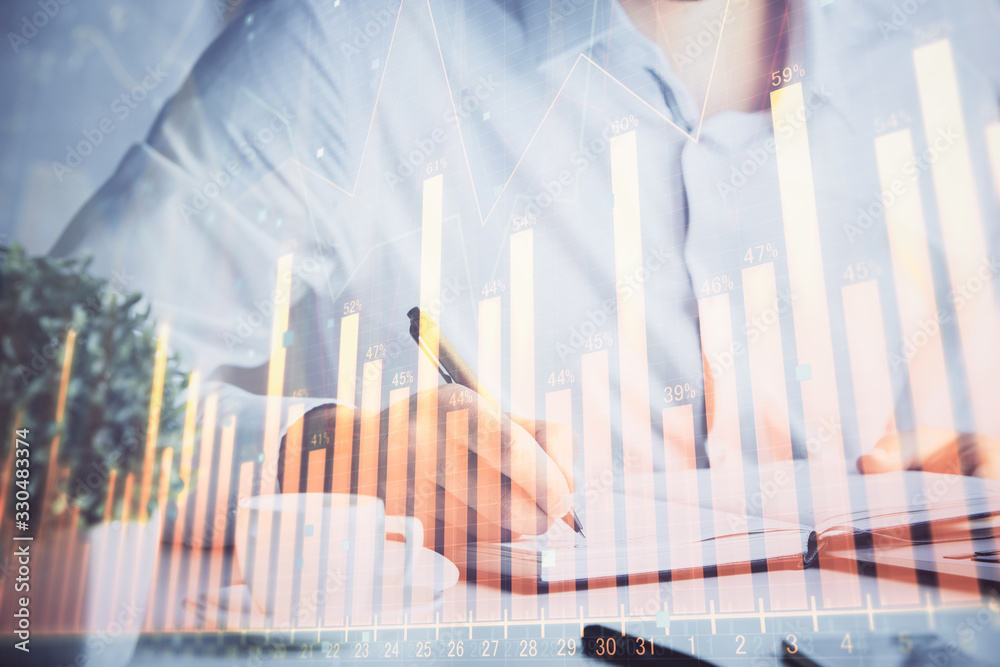 Double exposure of man's hands writing notes of stock market with forex chart. Double exposure of man's hands writing notes of stock market with forex chart.