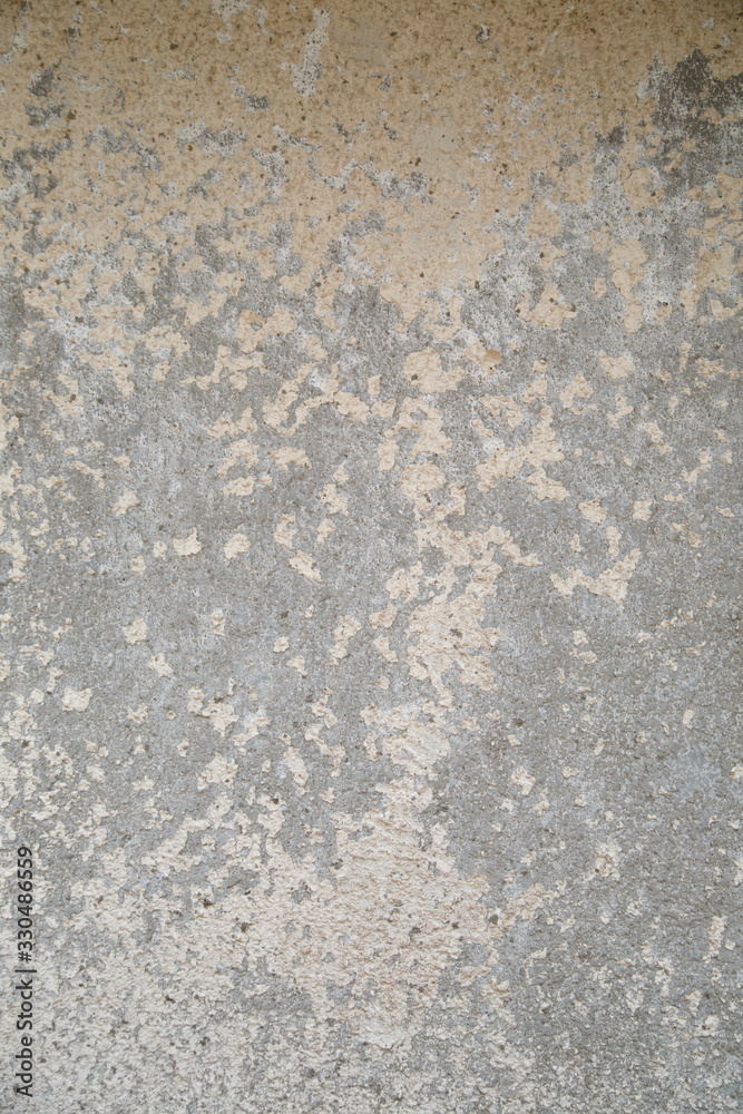 The surface of the old cemented surface in peeling beige paint.