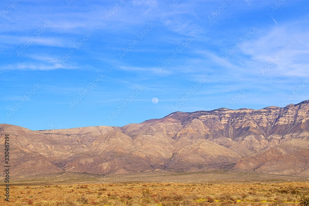 View of full moon rising over mountains during the evening View of full moon rising over mountains during the evening