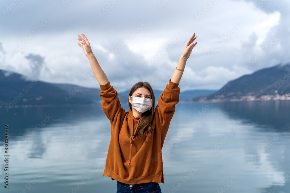 Fototapeta COVID-19 Young girl in city street wearing face mask protective for spreading of Coronavirus Disease 2019. . New travel cocept