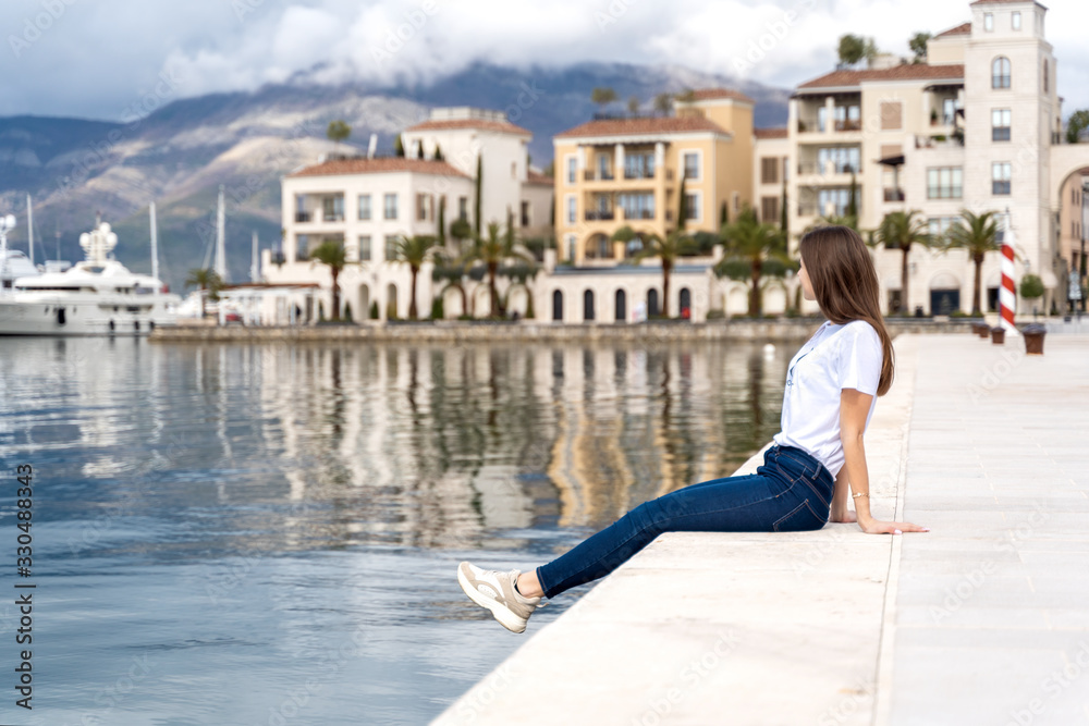 Young woman enjoying sea view in a marina port Montenegro