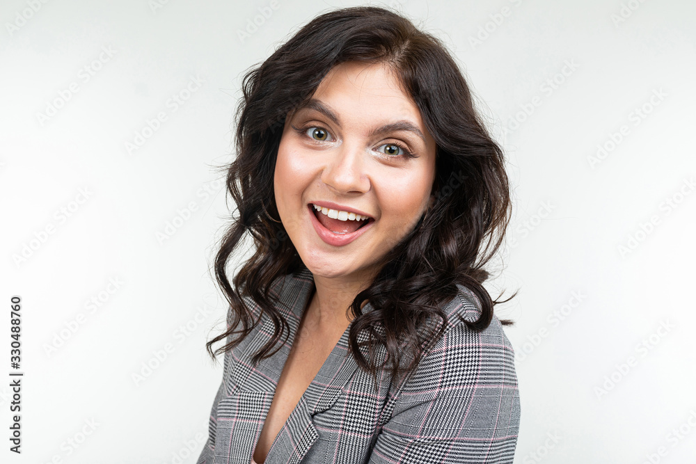 smiling charming lady in a gray jacket posing on a white studio background smiling charming lady in a gray jacket posing on a white studio background