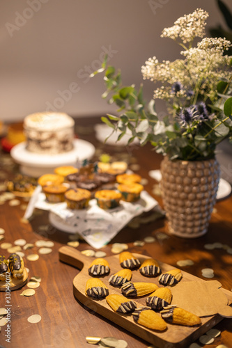 Wallpaper Mural Decorated Birthday table with different cupcakes, muffins, cake and madeleines with flowers and confetti. Torontodigital.ca