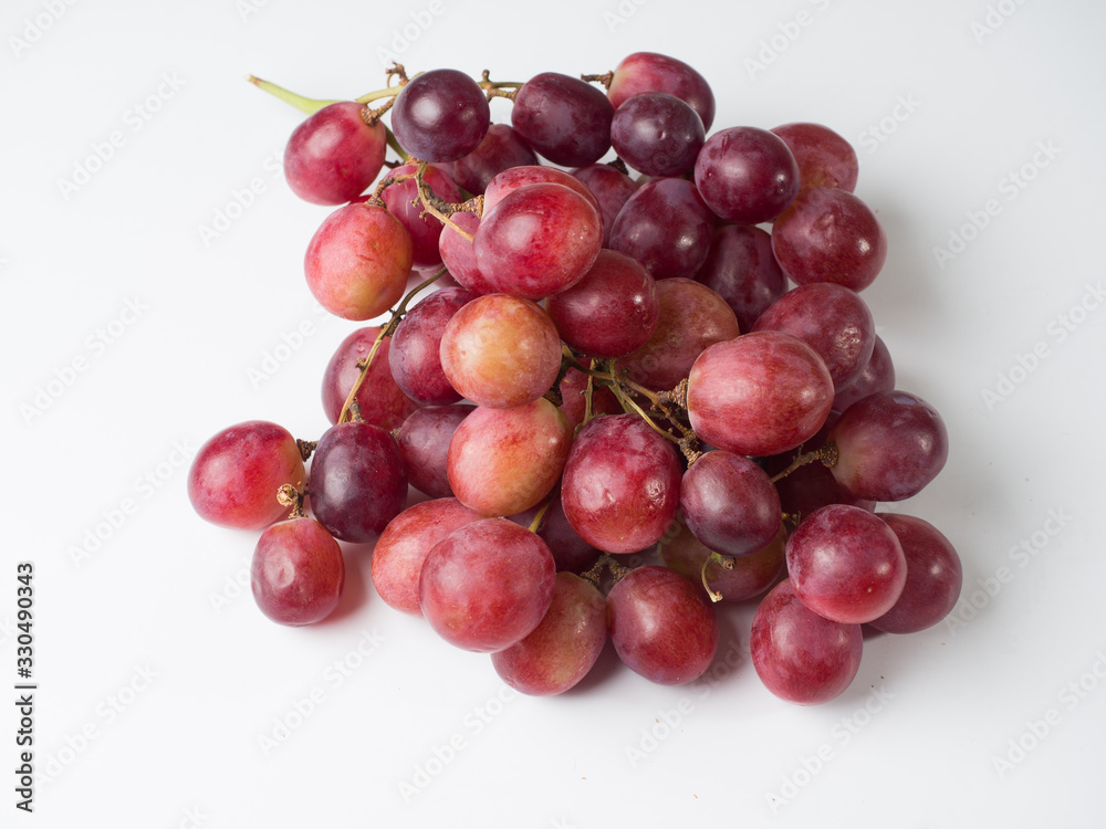 A bunch of pink large grapes on a white background. Studio photography