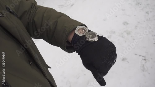 Mountaineer finds his route by his compass on a snowy winter day