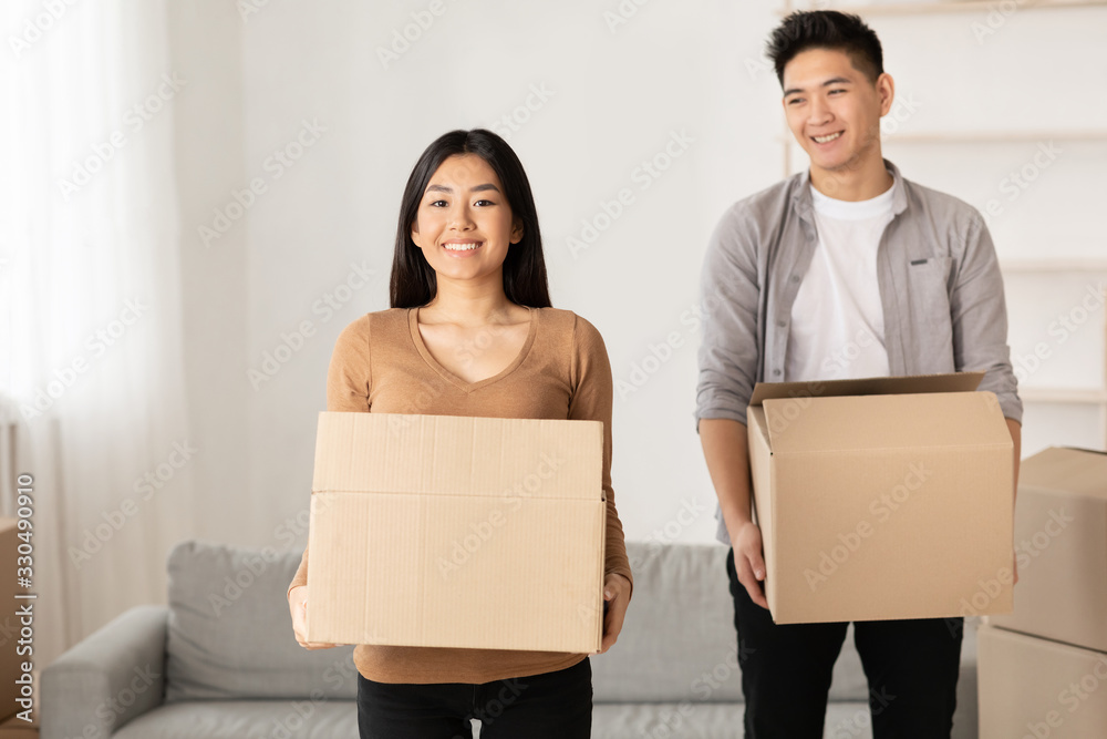 Asian man and woman holding cardboard boxes Asian man and woman holding cardboard boxes