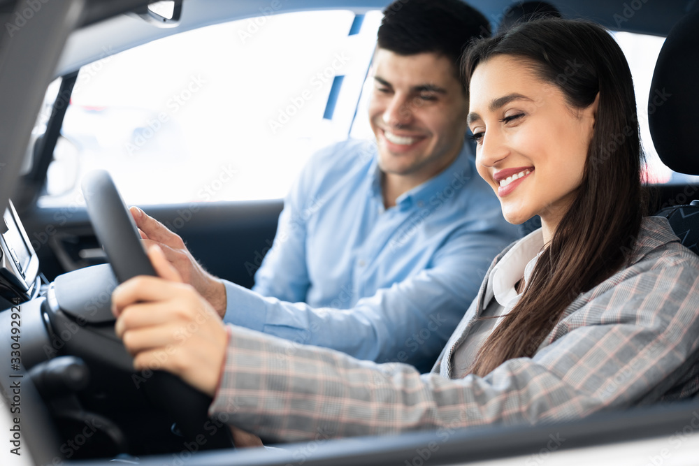 Young Spouses Choosing Car In Dealership Shop Young Spouses Choosing Car In Dealership Shop