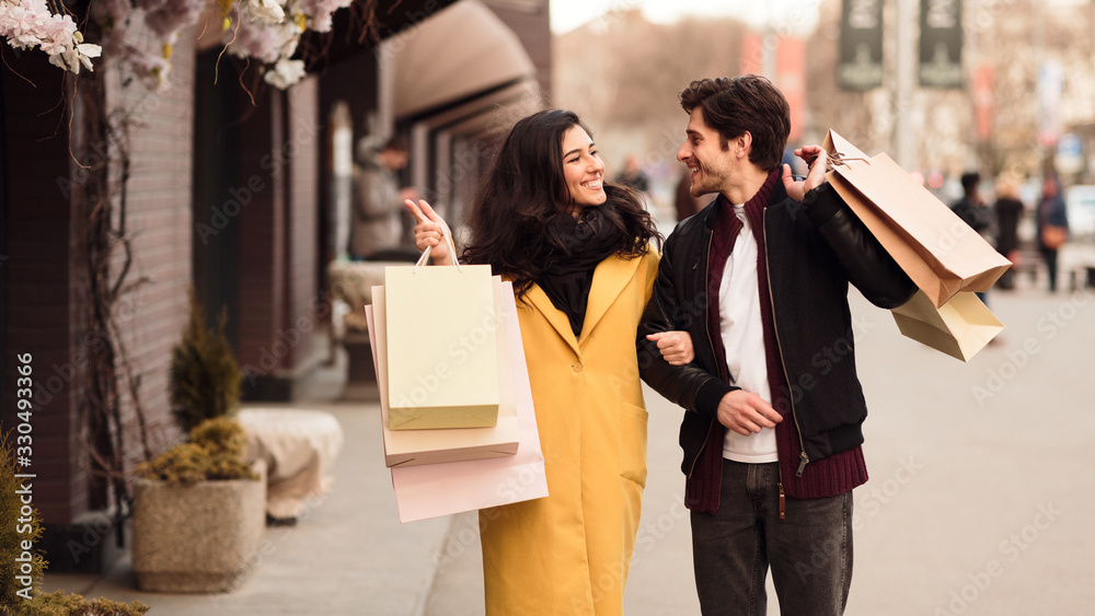 Woman showing something in shop window to her husband Woman showing something in shop window to her husband