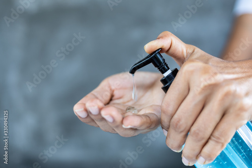 Closeup woman using alcohol gel hand sanitizer and protection against viruses and bacteria