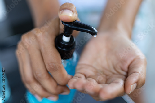 Closeup woman using alcohol gel hand sanitizer and protection against viruses and bacteria